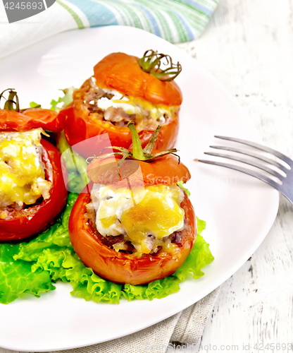 Image of Tomatoes stuffed with meat on lettuce in plate on light board