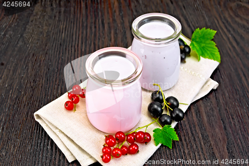 Image of Milk cocktail with red and black currant on dark board