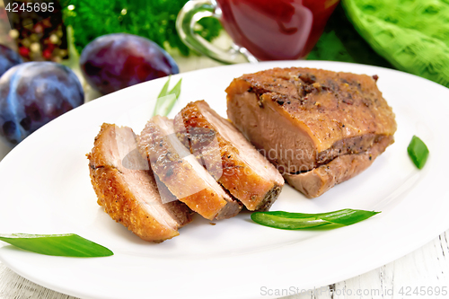 Image of Duck breast with cabbage and green onions in plate on board