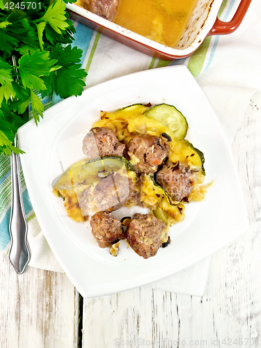 Image of Meatballs with zucchini and nuts in plate on board top