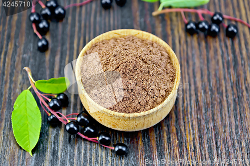 Image of Flour bird cherry in bowl with berries on dark board