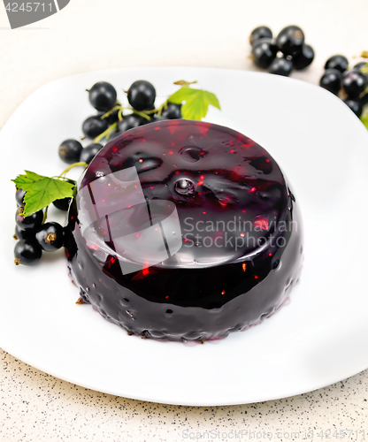 Image of Jelly from black currant with berries in plate on table