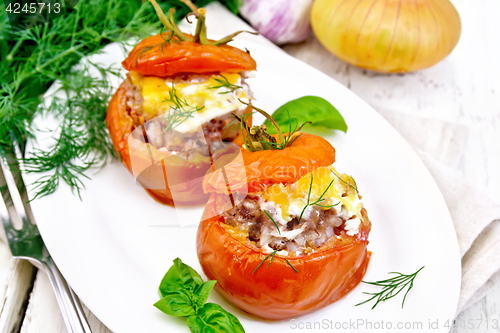 Image of Tomatoes stuffed with meat and rice in plate on light board