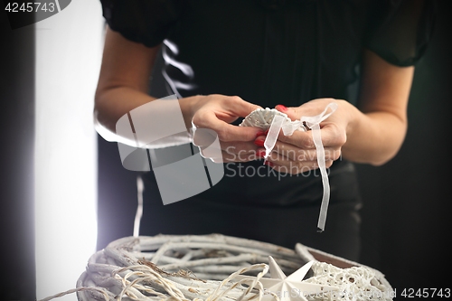 Image of Woman performs The Holiday wreath from natural materials