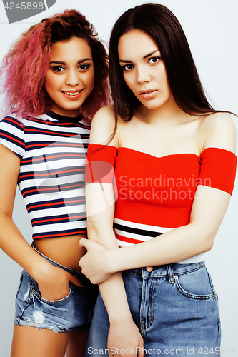 Image of lifestyle people concept: two pretty stylish modern hipster teen girl having fun together, diverse nation mixed races, happy smiling making selfie closeup