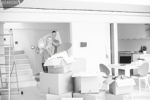 Image of couple carrying a carpet moving in to new home