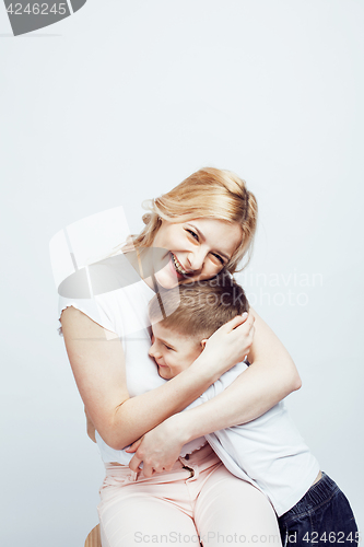 Image of young modern blond curly mother with cute son together happy smiling family posing cheerful on white background, lifestyle people concept, sister and brother friends