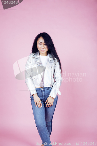 Image of young pretty smiling asian korean girl wearing modern fashion clothers on pink background, lifestyle people concept closeup