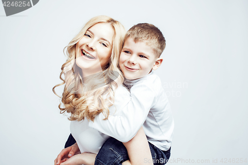 Image of young modern blond curly mother with cute son together happy smiling family posing cheerful on white background, lifestyle people concept, sister and brother friends