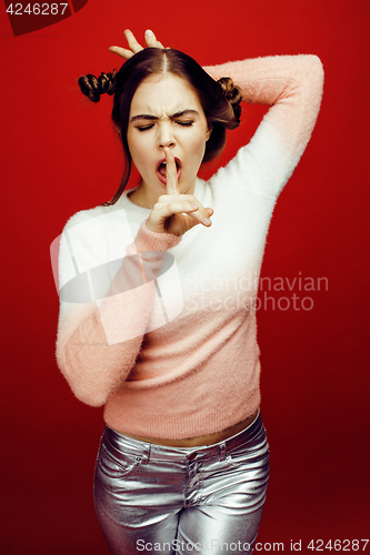Image of young pretty emitonal posing teenage girl on bright red background, happy smiling lifestyle people concept closeup