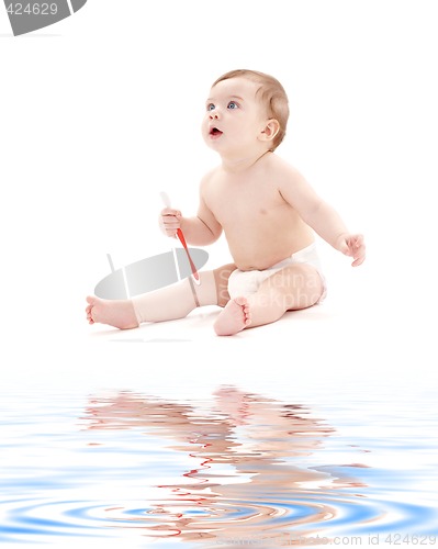 Image of baby boy in diaper with toothbrush