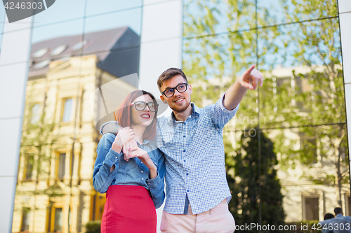 Image of Happy young couple standing at street of city and laughing on the bright sunny day