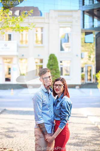 Image of Happy young couple standing at street of city and laughing on the bright sunny day