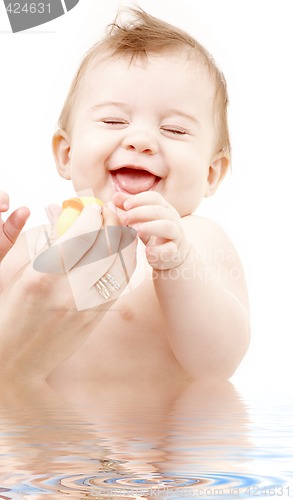 Image of laughing baby boy in water playing with rubber duck