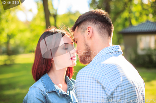 Image of Happy young couple at park standing and laughing on the bright sunny day