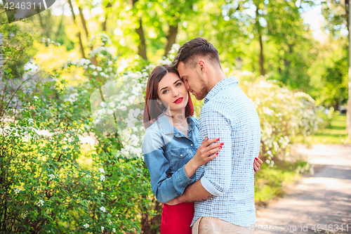 Image of Happy young couple at park standing and laughing on the bright sunny day