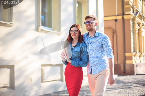 Image of Happy young couple standing at street of city and laughing on the bright sunny day