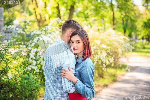 Image of Happy young couple at park standing and laughing on the bright sunny day