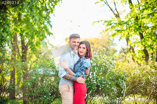 Image of Happy young couple at park standing and laughing on the bright sunny day