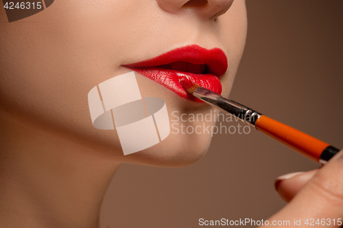 Image of Beautiful female lips with make-up and brush