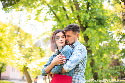 Image of Happy young couple at park standing and laughing on the bright sunny day