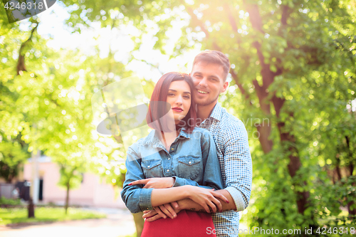 Image of Happy young couple at park standing and laughing on the bright sunny day