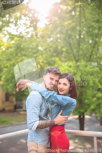 Image of Happy young couple at park standing and laughing on the bright sunny day