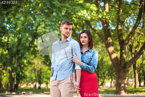 Image of Happy young couple at park standing and laughing on the bright sunny day