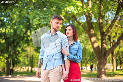 Image of Happy young couple at park standing and laughing on the bright sunny day