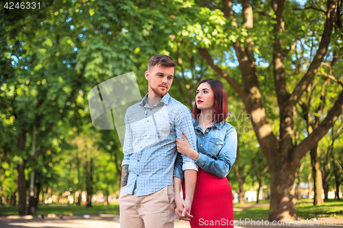 Image of Happy young couple at park standing and laughing on the bright sunny day