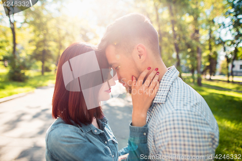 Image of Happy young couple at park standing and laughing on the bright sunny day