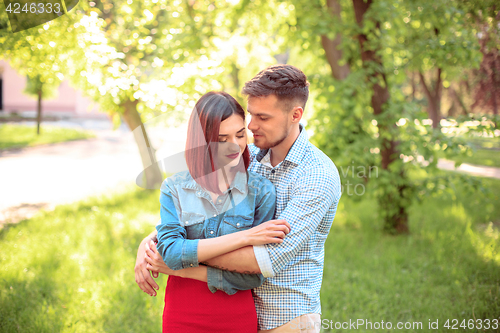 Image of Happy young couple at park standing and laughing on the bright sunny day