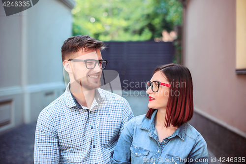 Image of Happy young couple standing at street of city and laughing on the bright sunny day