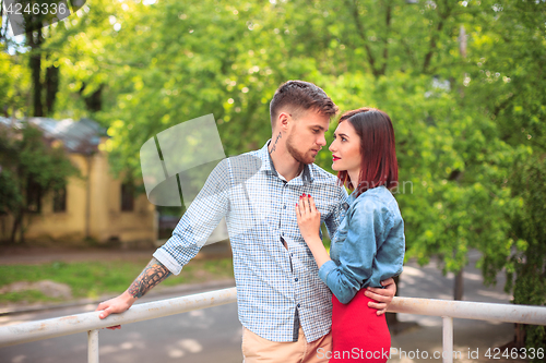 Image of Happy young couple at park standing and laughing on the bright sunny day