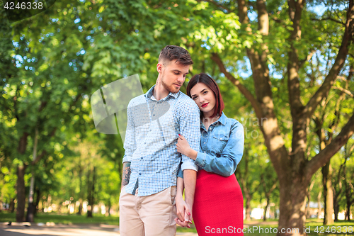 Image of Happy young couple at park standing and laughing on the bright sunny day