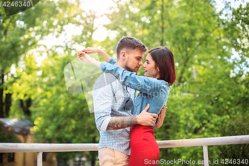Image of Happy young couple at park standing and laughing on the bright sunny day