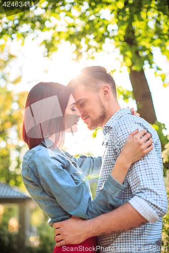 Image of Happy young couple at park standing and laughing on the bright sunny day