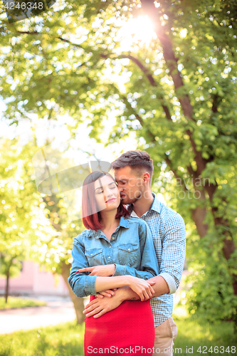 Image of Happy young couple at park standing and laughing on the bright sunny day