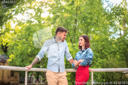 Image of Happy young couple at park standing and laughing on the bright sunny day