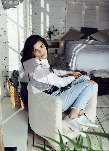Image of young pretty woman in her bedroom sitting in chair, lifestyle people concept