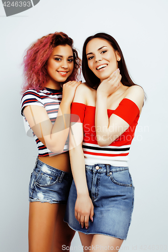 Image of lifestyle people concept: two pretty stylish modern hipster teen girl having fun together, diverse nation mixed races, happy smiling making selfie closeup