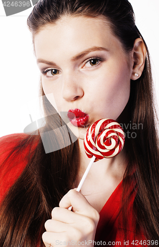 Image of young pretty brunette girl with red candy posing on white background isolated