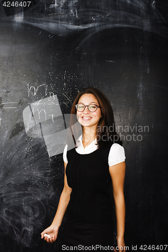 Image of portrait of happy cute student in classroom at blackboard back t