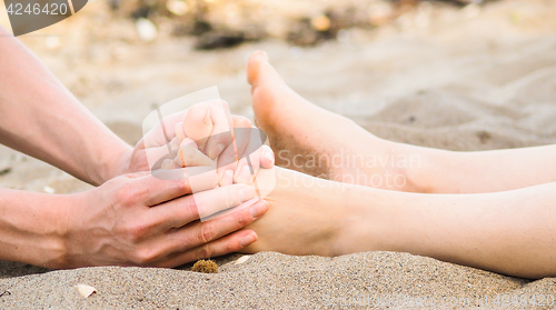 Image of Foot massage on a beach in sand, male and female caucasian