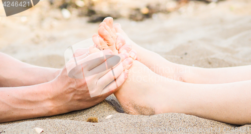 Image of Foot massage on a beach in sand, male and female caucasian