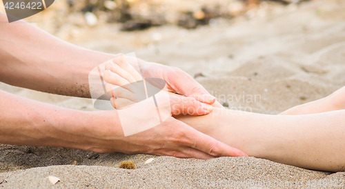 Image of Foot massage on a beach in sand, male and female caucasian