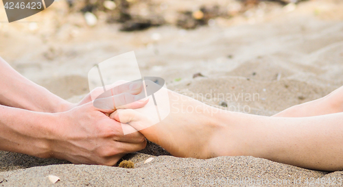 Image of Foot massage on a beach in sand, male and female caucasian