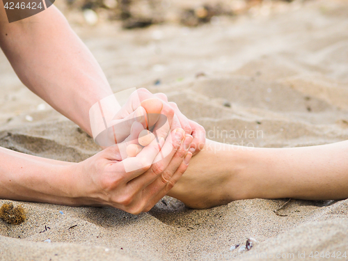 Image of Foot massage on a beach in sand, male and female caucasian