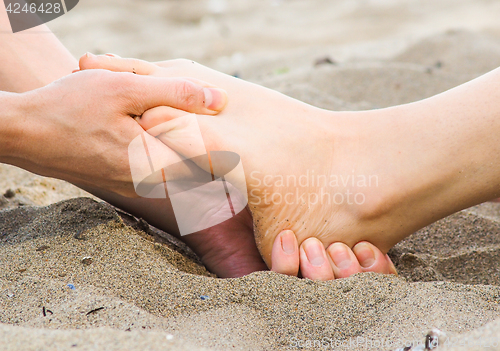 Image of Foot massage on a beach in sand, male and female caucasian