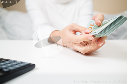 Image of business, finance, saving, banking and people concept - close up of woman hands counting us dollar money